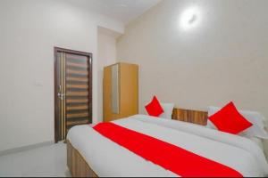 a bedroom with a large bed with red pillows at OYO Flagship Hotel Soho in Noida