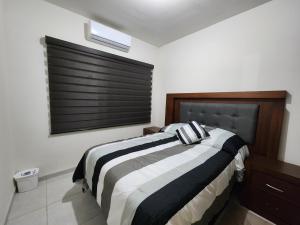 Un dormitorio con una cama en blanco y negro y una ventana en Casa Descanso de Mamá, en San Luis Potosí
