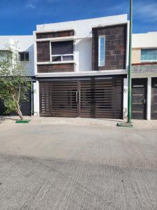 un edificio con puertas de madera de garaje en una calle en Casa Descanso de Mamá, en San Luis Potosí