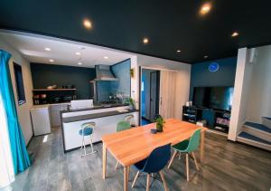 uma cozinha e sala de jantar com uma mesa de madeira e cadeiras em QUENOS em Oshima