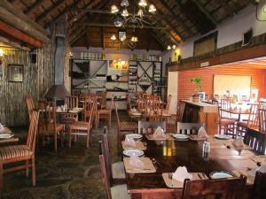 a restaurant with wooden tables and chairs and a dining room at The Woodsman Bed and Breakfast in Sabie