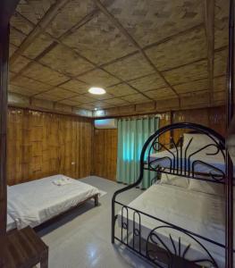 a bedroom with two beds in a wooden room at The Blessed Purple Bamboo Beach Resort in Alaminos +49 photos
