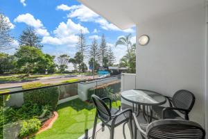 balcone con tavolo, sedie e vista sulla strada di Windward 4, 3 bedroom unit ocean front a Mooloolaba