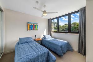 una camera da letto con due letti e una finestra di Windward 4, 3 bedroom unit ocean front a Mooloolaba