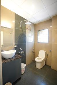 a bathroom with a toilet and a sink at THE EKAH COMFORTS in Bangalore