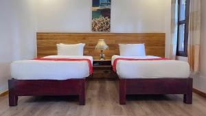 ルアンパバーンにあるLuang Prabang Villa Oasisのベッド2台が隣同士に設置された部屋です。