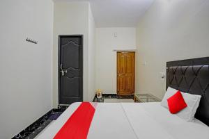 a bedroom with a large white bed with red pillows at OYO Flagship J.d.p Guest House in Varanasi