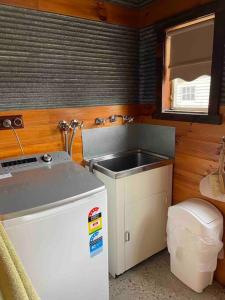 a small kitchen with a sink and a refrigerator at Unique, Rustic Stone Cottage in Canadian