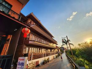 ルーイにあるSuksomboonhotelの建物横の歩道を歩く者