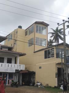 ein gelbes Gebäude mit einer Palme davor in der Unterkunft Eden Sea View in Talpe