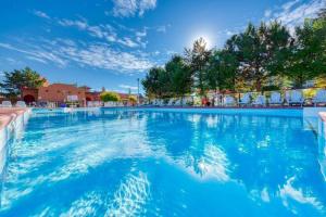 a large swimming pool with blue water at Hilltop Haven at La Casa Resort Lakeside Kelowna in Kelowna
