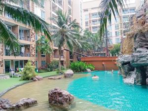 a pool in a hotel with people swimming in it at Atlantis Condo Resort in Jomtien Beach