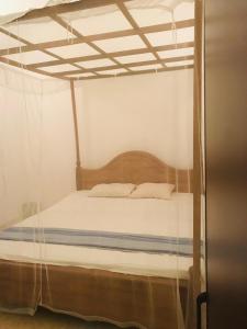 a bedroom with a canopy bed with white sheets at Sun Shine House in Matara