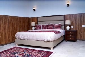 a bedroom with a large bed with red pillows at Cedar Lodges Resort and Residences Galiyat in Chhāngla Gali