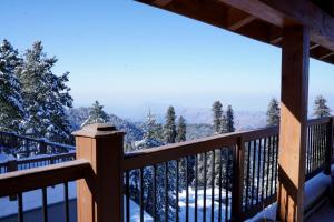 a view from the deck of a cabin in the snow at Cedar Lodges Resort and Residences Galiyat in Chhāngla Gali