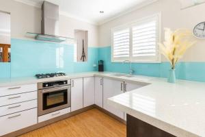 - une cuisine avec des placards blancs et des murs bleus dans l'établissement NEW! Modern, Cozy 2BR Home Away from Home w/ Wifi, à Perth