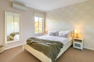 - une chambre avec un grand lit et un miroir dans l'établissement NEW! Modern, Cozy 2BR Home Away from Home w/ Wifi, à Perth