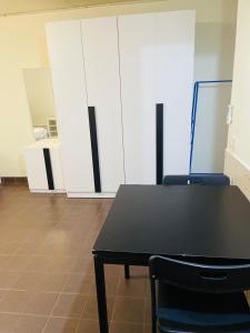 a black table and chairs in a room with white cabinets at Muangthong C3near Impact in Nonthaburi