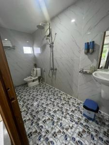 y baño con ducha, aseo y lavamanos. en Côn Đảo Xanh Hotel, en Con Dao