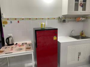 een keuken met een rode koelkast en een wastafel bij Muangthong C3,C4near Impact in Nonthaburi