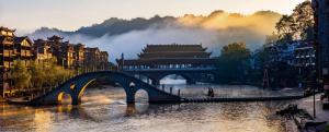 a bridge over a river in a city at 凤凰古城宝庆民宿 in Fenghuang County