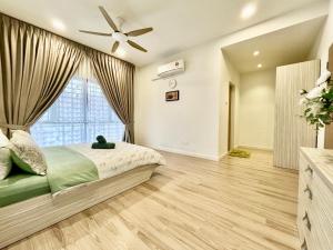 een slaapkamer met een bed en een plafondventilator bij Serene Homestay Semenyih - Endlot House 4BR for 9 pax in Semenyih