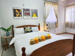 1 dormitorio con 1 cama grande con mantas amarillas de punto en Klang Prima Bayu Cozy 4-Room Retreat en Klang