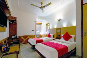 ein Hotelzimmer mit 2 Betten und einem TV in der Unterkunft Hotel Cottage Yes Please - New Delhi in Neu-Delhi