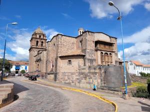 een oud stenen gebouw met een toren op een straat bij Pacheco APARTMENT in Cuzco