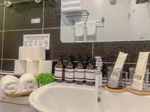 a bathroom sink with towels and bottles on a counter at CRAFT 7th Boutique Nimman in Chiang Mai