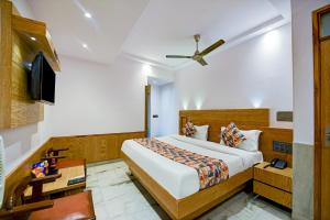 1 dormitorio con 1 cama grande y TV en Hotel Cottage Yes Please - New Delhi, en Nueva Delhi