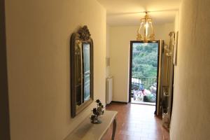 a hallway with a mirror and a table and a window at 5 Lands Stone Cottage in Levanto