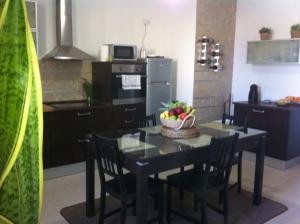 a kitchen with a table with a bowl of fruit on it at Genista Apartment in Kalkara