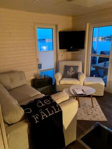 a living room with a couch and a table at Hausboot Snowbird Lübeck mit großem Sonnendeck in Lübeck