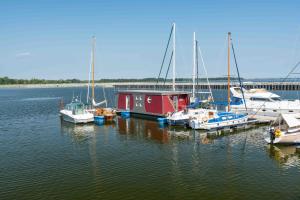 a group of boats docked at a dock in the water at Hausboot Lewisia mit großem Sonnendeck inklusive Wäschepaketen in Barth