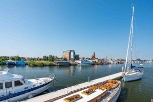 three boats are docked at a dock in a harbor at Hausboot Lewisia mit großem Sonnendeck inklusive Wäschepaketen in Barth