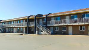 a large building with a staircase in a parking lot at Corcoran Country Inn in Corcoran