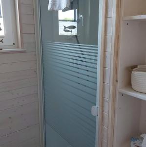 a glass shower door in a bathroom at Knobis DREAM PLACE in Fehmarnsund