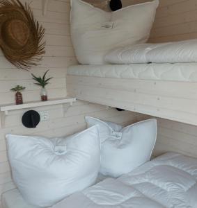 a room with white pillows and pillows on a bed at Knobis DREAM PLACE in Fehmarnsund