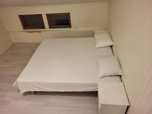 a small bedroom with a large white bed with two pillows at One Bedroom Apartment Kjeller Lillestrøm - 2 mins from OSLOMET in Lillestrøm