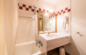 y baño con lavabo, bañera y espejo. en Les Résidences de Valmorel - maeva Home - 2 Pièces 5 Personnes Confort 75, en Valmorel