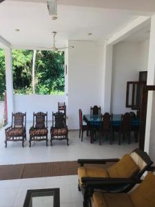 a living room with a couch and chairs and a table at Sun Shine House in Matara