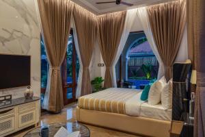 a bedroom with a bed and a large window at The Bloomers Villa in Vagator