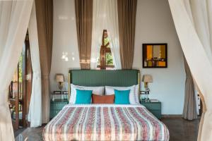 a bedroom with a bed with blue and orange pillows at The Bloomers Villa in Vagator