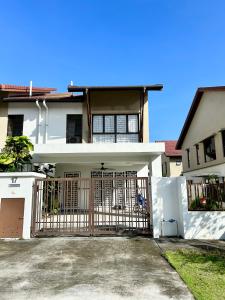 a white house with a gate in front of it at Serene Homestay Semenyih - Endlot House 4BR for 9 pax in Semenyih