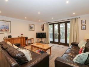 a living room with a leather couch and a table at Gillybeck in Ambleside