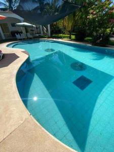 una gran piscina azul con suelo de baldosa en Casa de Descanso en Monterrico en Monterrico