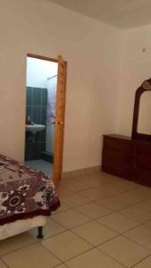 een slaapkamer met een spiegel, een bed en een wastafel bij Casa de Descanso en Monterrico in Monterrico