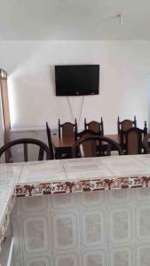 a dining room with a table with chairs and a flat screen tv at Casa de Descanso en Monterrico in Monterrico