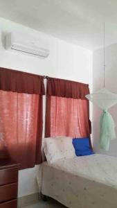 1 dormitorio con cama y cortina roja en Casa de Descanso en Monterrico en Monterrico